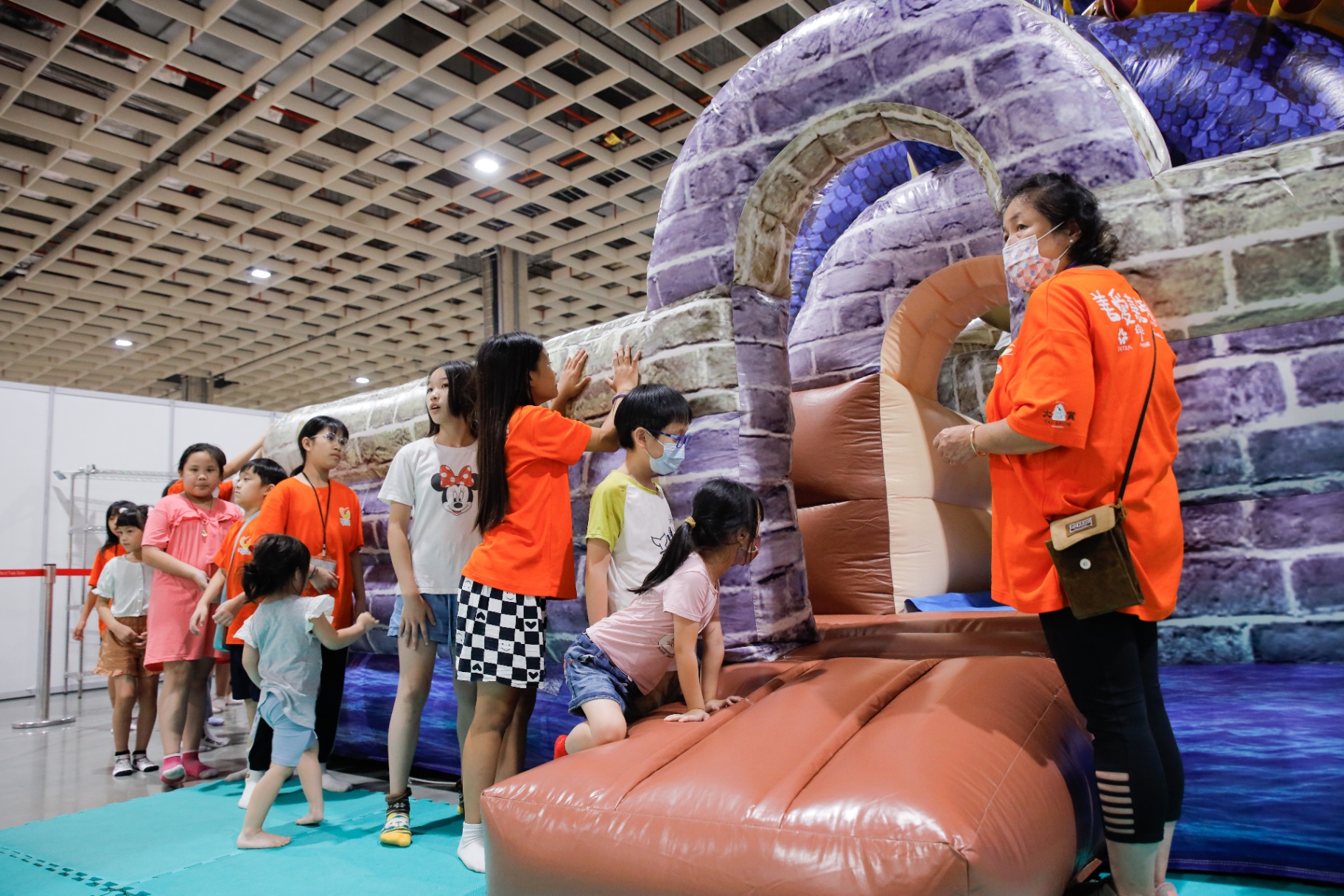 孩子排隊體驗紫色城堡造型氣墊溜滑梯